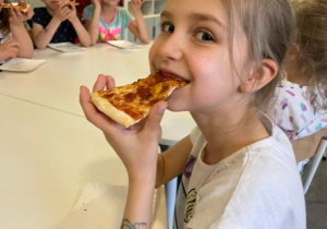 Dziewczynka je pizzę